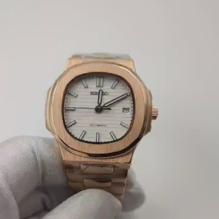 A close up video of a Gold Seiko Mod Nautilus with a white dial 